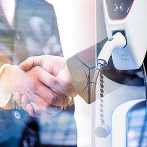 double exposure of business handshake and silhouette of wind turbine at sunset with electric car battery charger station. Green energy for new innovative technology EV Electrical vehicle concept.